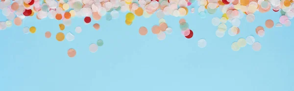 Panoramic shot of colorful confetti on blue — Stock Photo