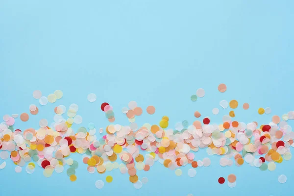 Vue de dessus des confettis colorés sur bleu — Photo de stock