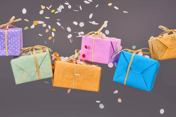 Falling confetti near colorful gift boxes on grey — Stock Photo