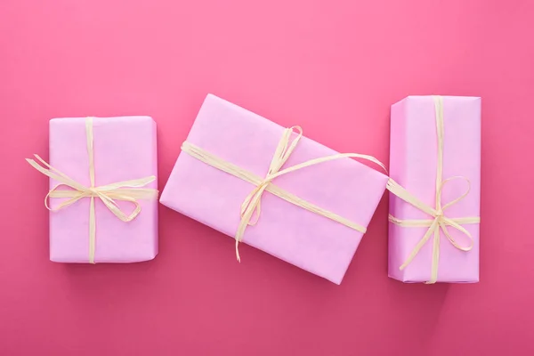 Top view of wrapped presents with bows on pink — Stock Photo