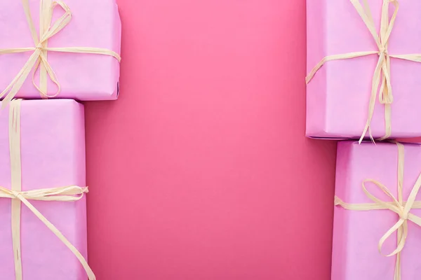 Top view of wrapped presents with bows on pink with copy space — Stock Photo