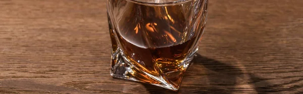 Panoramic shot of brandy in glass on wooden table — Stock Photo