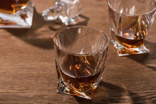 Selective focus of brandy in glasses on wooden table — Stock Photo