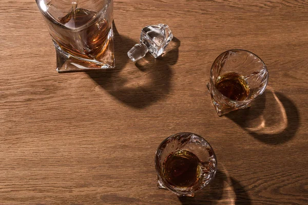 Vista superior de brandy en vasos y decantador sobre mesa de madera - foto de stock