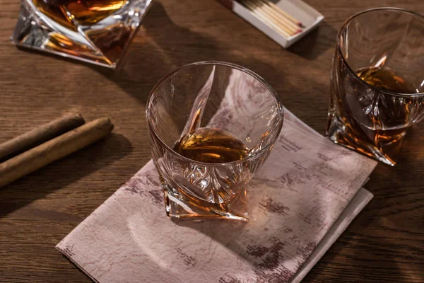 Verres Brandy avec carte, cigares et allumettes sur table en bois — Photo de stock