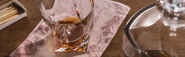 Verre de brandy sur carte avec carafe et allumettes sur table en bois, vue panoramique — Photo de stock