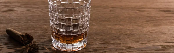 Glass of brandy with cigar on wooden table, panoramic shot — Stock Photo