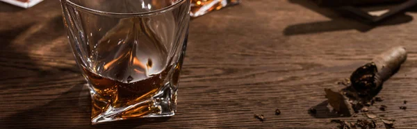 Brandy em vidro com charuto na mesa de madeira, tiro panorâmico — Fotografia de Stock