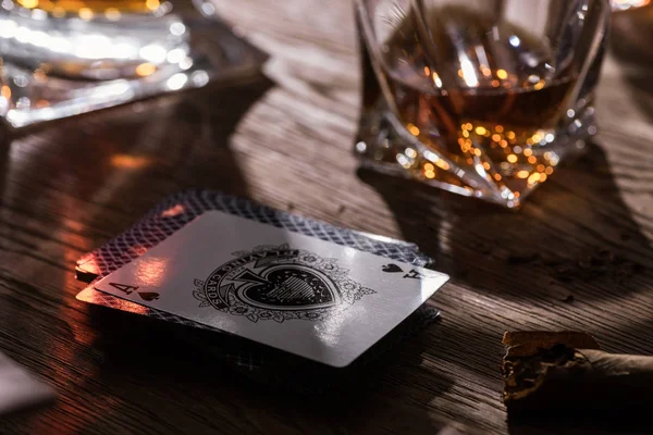 KYIV, UCRANIA - 7 DE NOVIEMBRE DE 2019: Vaso de brandy con cigarro y cartas en mesa de madera - foto de stock