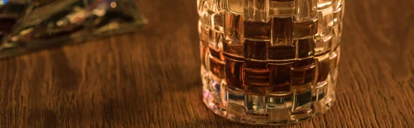 Foto panorámica de copa de brandy sobre mesa de madera - foto de stock