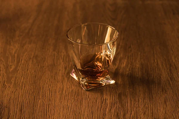 Glass of brandy on wooden table — Stock Photo