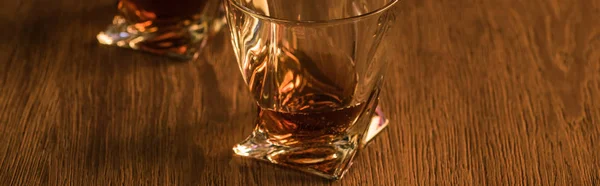 Two glasses of brandy on wooden table, panoramic shot — Stock Photo