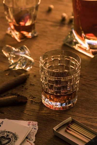 KYIV, UCRANIA - 7 DE NOVIEMBRE DE 2019: Vasos de brandy con cigarros, partidos y cartas en la mesa - foto de stock