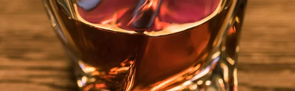 Close up view of brandy in glass on wooden table, panoramic shot — Stock Photo