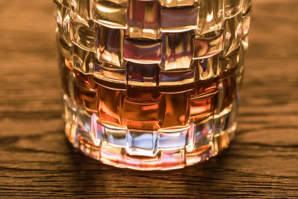 Close up view of brandy in textured glass on wooden table — Stock Photo