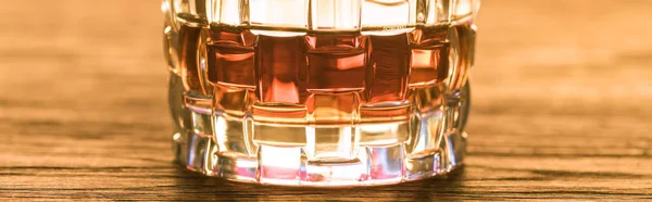 Close-up vista de conhaque em vidro sobre mesa de madeira, tiro panorâmico — Fotografia de Stock