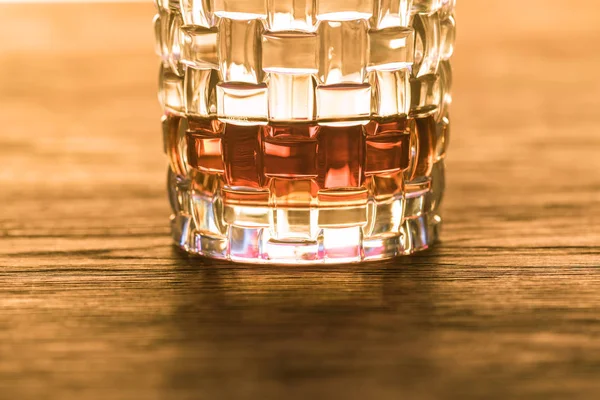 Brandy en vidrio texturizado sobre mesa de madera - foto de stock