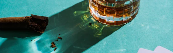 Panorâmica tiro de vidro em conhaque com charuto no fundo verde — Fotografia de Stock