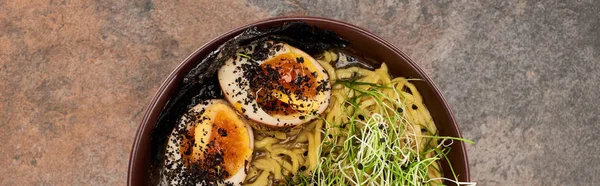 Vista dall'alto di ramen piccante con uovo su superficie di pietra, colpo panoramico — Foto stock