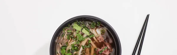 Top view of pho in bowl near chopsticks on white background, panoramic shot — Stock Photo