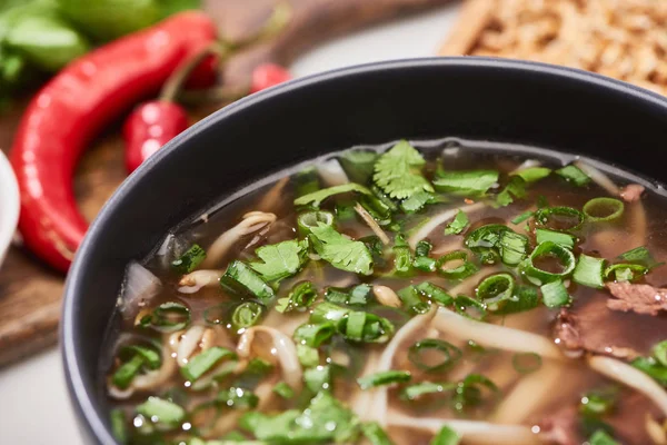 Close up view of pho with noodles, meat, cilantro and green onion in bowl — Stock Photo