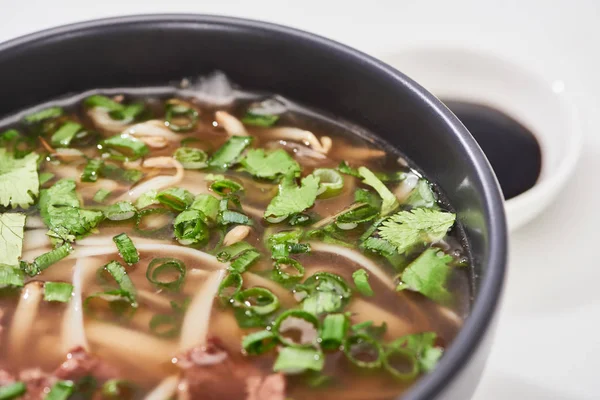 Vista de perto do pho com macarrão, carne, coentro e cebola verde na tigela — Fotografia de Stock