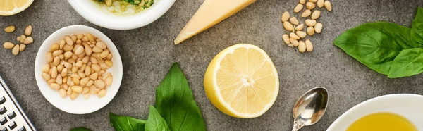 Top view of pesto sauce raw ingredients and cooking utensils on grey surface, panoramic shot — Stock Photo