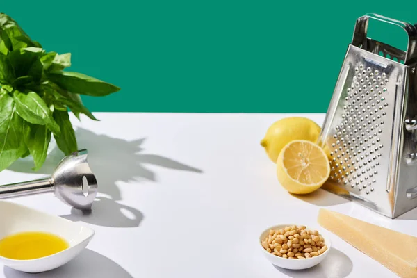 Соус песто сирі інгредієнти та посуд на білому столі ізольовані на зеленому — стокове фото