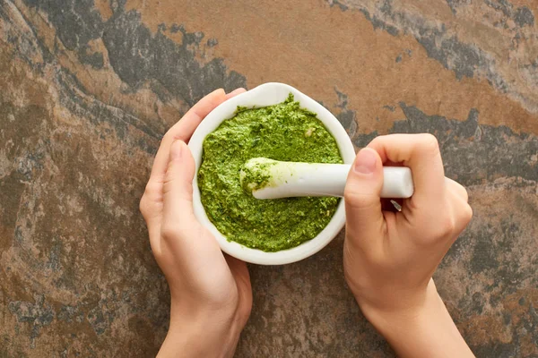 Vista cortada de mulher cozinhando molho pesto na superfície de pedra — Fotografia de Stock