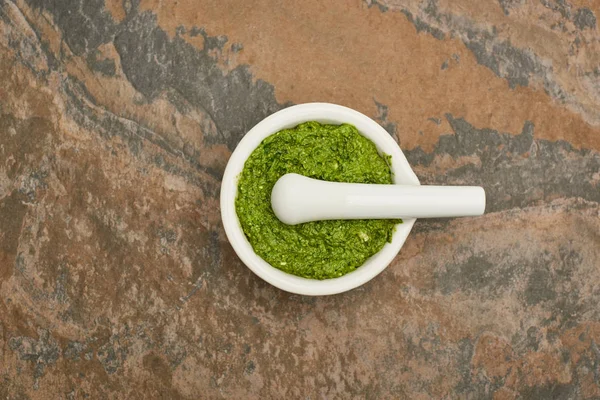 Top view of pesto sauce in pounder on stone surface — Stock Photo