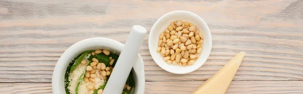 Top view of pesto sauce raw ingredients in pounder on wooden table, panoramic shot — Stock Photo