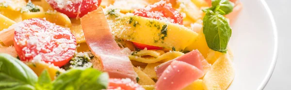 Vista de cerca de la deliciosa Pappardelle con tomates, parmesano, salsa de pesto, albahaca y jamón - foto de stock