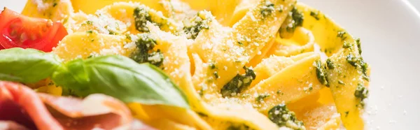Close up view of delicious Pappardelle with tomatoes, Parmesan, pesto sauce, basil and prosciutto — Stock Photo