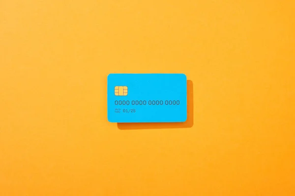 Top view of blue credit card template on orange background — Stock Photo