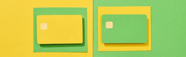 Top view of empty credit cards on green and yellow background, panoramic shot — Stock Photo