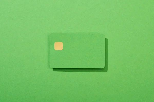 Vista superior de la colorida tarjeta de crédito vacía sobre fondo verde - foto de stock