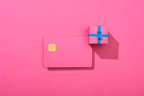 Top view of colorful empty credit card with gift box on pink background — Stock Photo