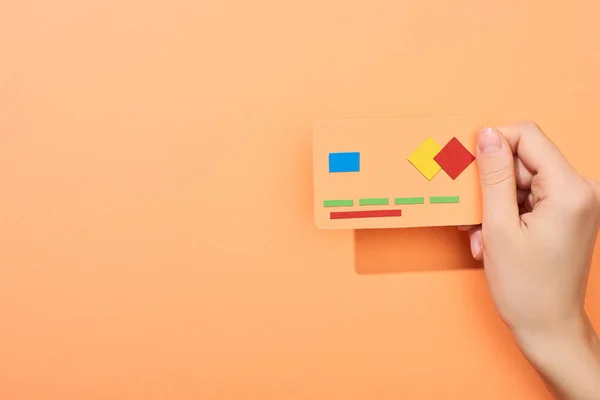 Cropped view of woman holding credit card template on peach background — Stock Photo