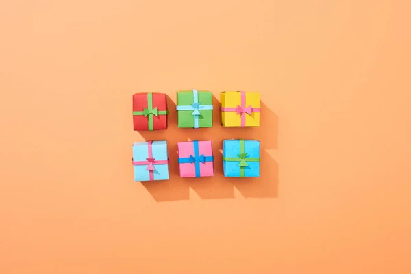 Top view of multicolored small gift boxes on peach background — Stock Photo