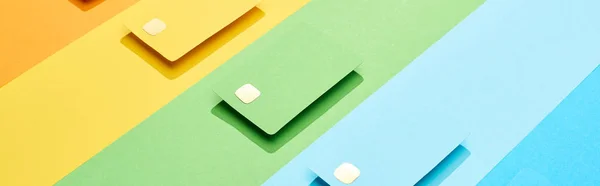 Cartes de crédit vides multicolores sur fond arc-en-ciel, panoramique — Photo de stock