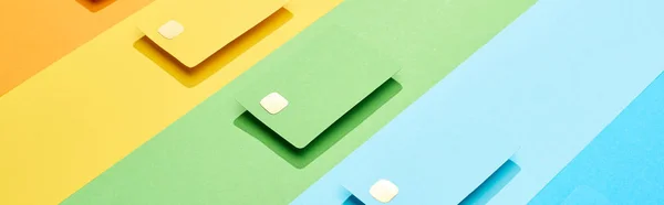 Tarjetas de crédito vacías multicolores sobre fondo de arco iris, plano panorámico - foto de stock