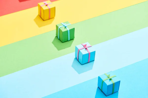 Разноцветные подарочные коробки на радужном фоне — стоковое фото