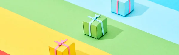Scatole regalo multicolore su sfondo arcobaleno, colpo panoramico — Foto stock
