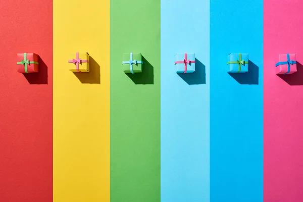 Top view of multicolored gift boxes on rainbow background — Stock Photo