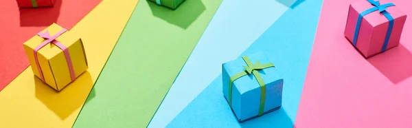 Різнокольорові подарункові коробки, розкидані на веселковому фоні, панорамний знімок — стокове фото
