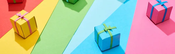 Cajas de regalo multicolores dispersos en el fondo del arco iris, plano panorámico - foto de stock