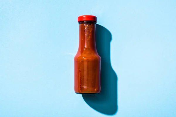 Vista dall'alto della bottiglia con ketchup su sfondo blu — Foto stock