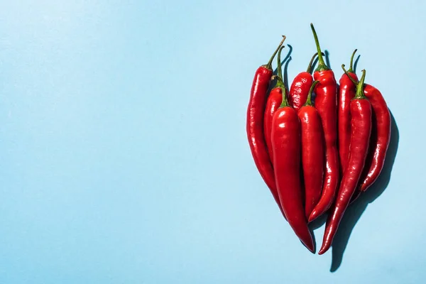 Top view of fresh organic chili peppers on blue background — Stock Photo