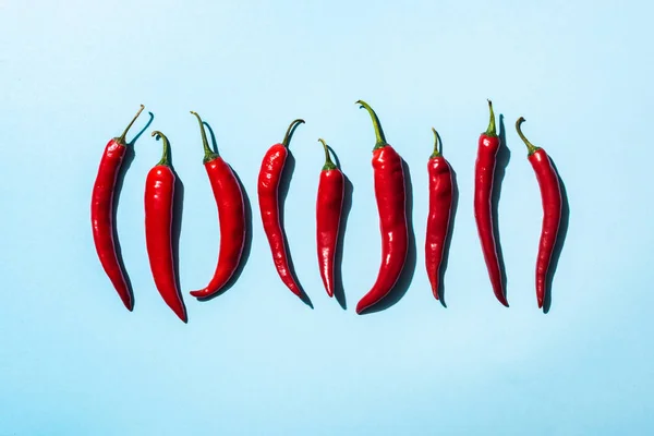 Top view of ripe chili peppers on blue surface — Stock Photo