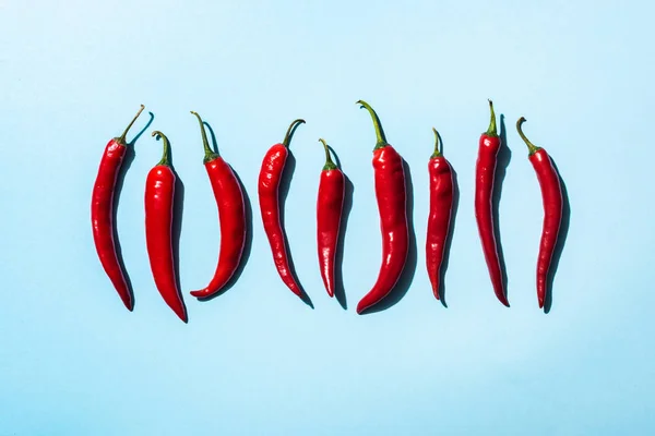 Vue de dessus des piments mûrs sur la surface bleue — Photo de stock